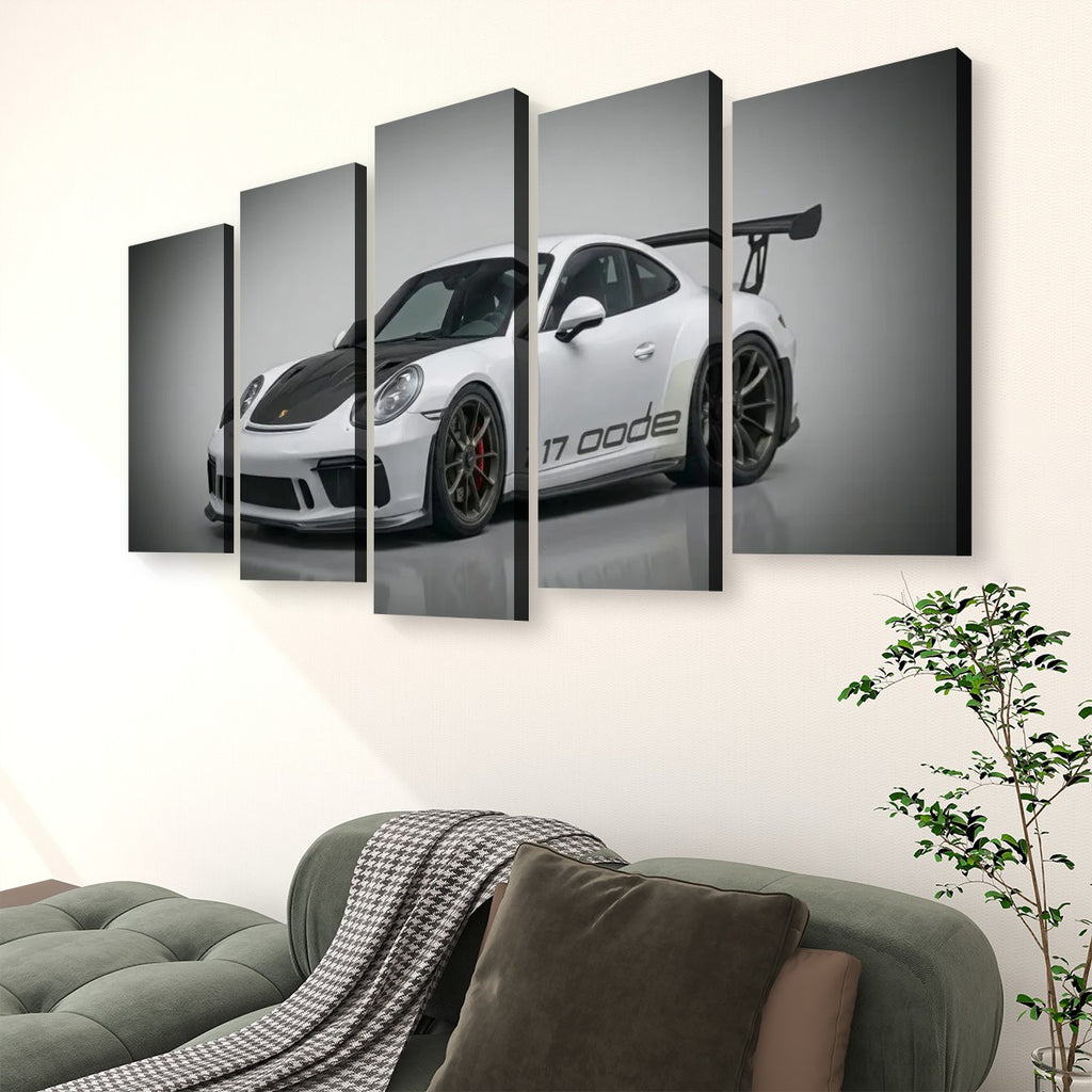 A 5-panel canvas wall art set depicting a white Porsche 911 with a black hood and rear wing, displayed on a wall above a green sofa in a living room setting.