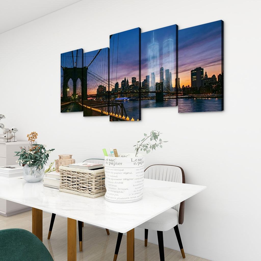 A five-panel canvas wall art set depicting the Brooklyn Bridge and New York City skyline at dusk, displayed on a white wall above a dining table in a modern room setting.