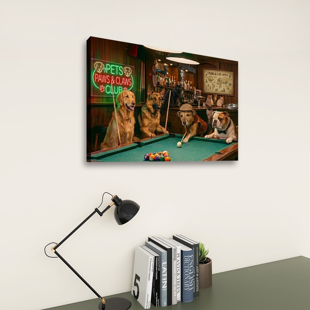 A rectangular wall art print showing several dogs playing pool in a bar scene, displayed above a desk with a black lamp and books against a light gray wall.