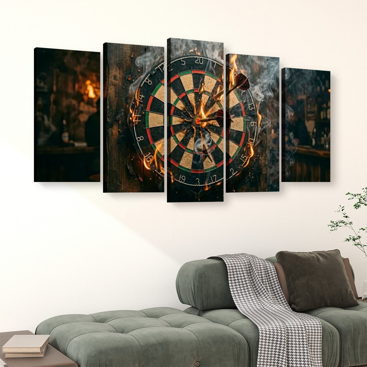 A 5-panel canvas wall art set depicting a dramatic dartboard scene with fire and smoke, displayed above a green sofa in a modern living room setting.