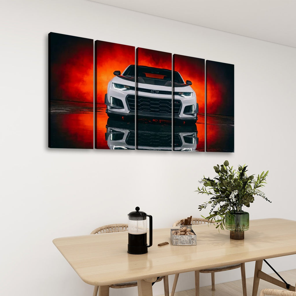 A five-panel canvas wall art set depicting a white Camaro sports car against a dramatic red and black background, displayed on a white wall above a dining table with a vase of greenery and a French press.