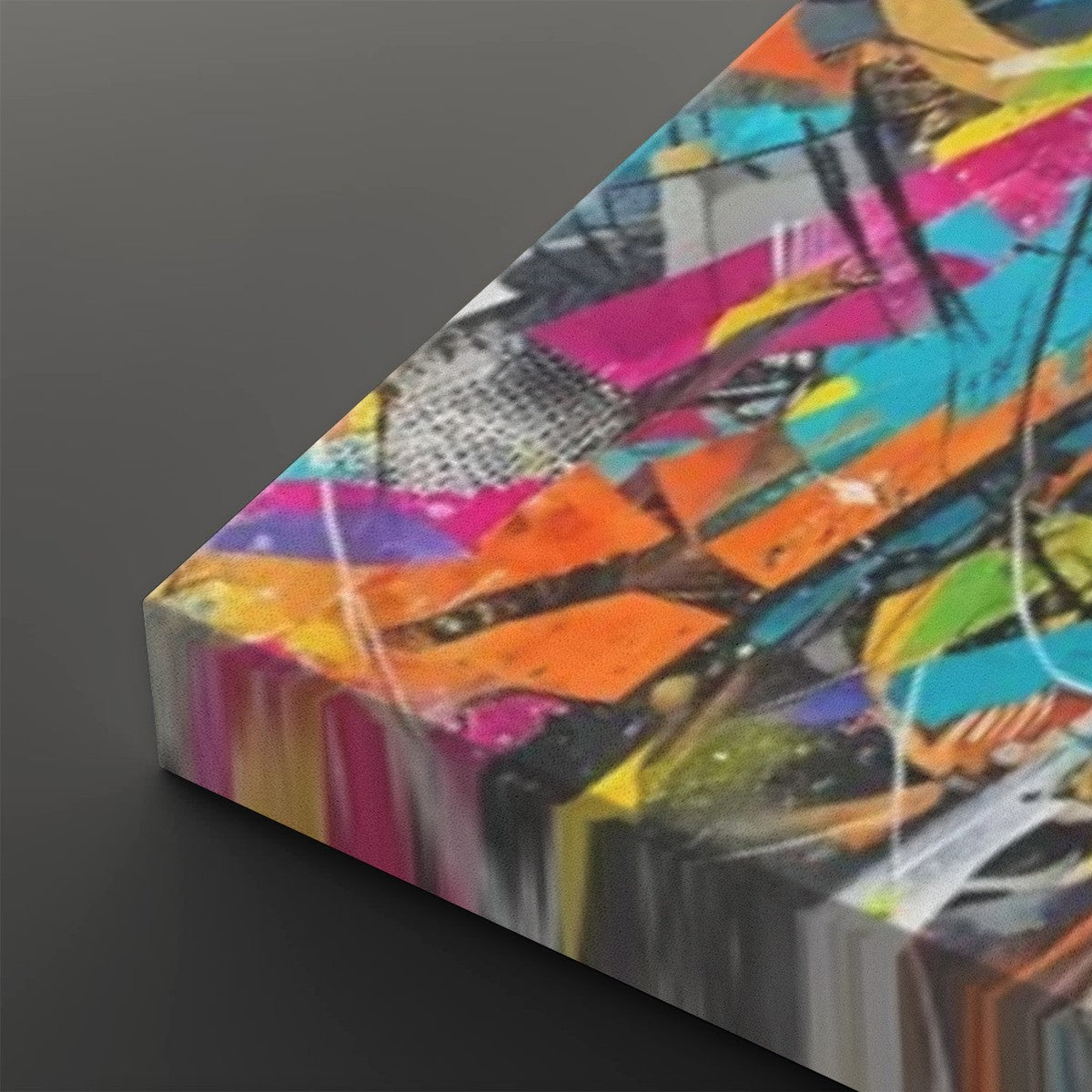 A rectangular canvas print featuring a vibrant, multicolored abstract graffiti-style design, shown at an angle against a dark gray background.
