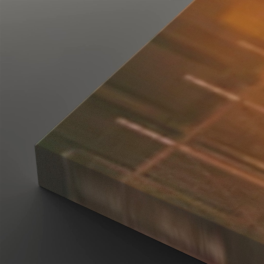 A close-up of a rectangular panel or board shown at an angle, with a warm coppery-brown reflective surface and a darker gray side edge, photographed on a dark gray background.