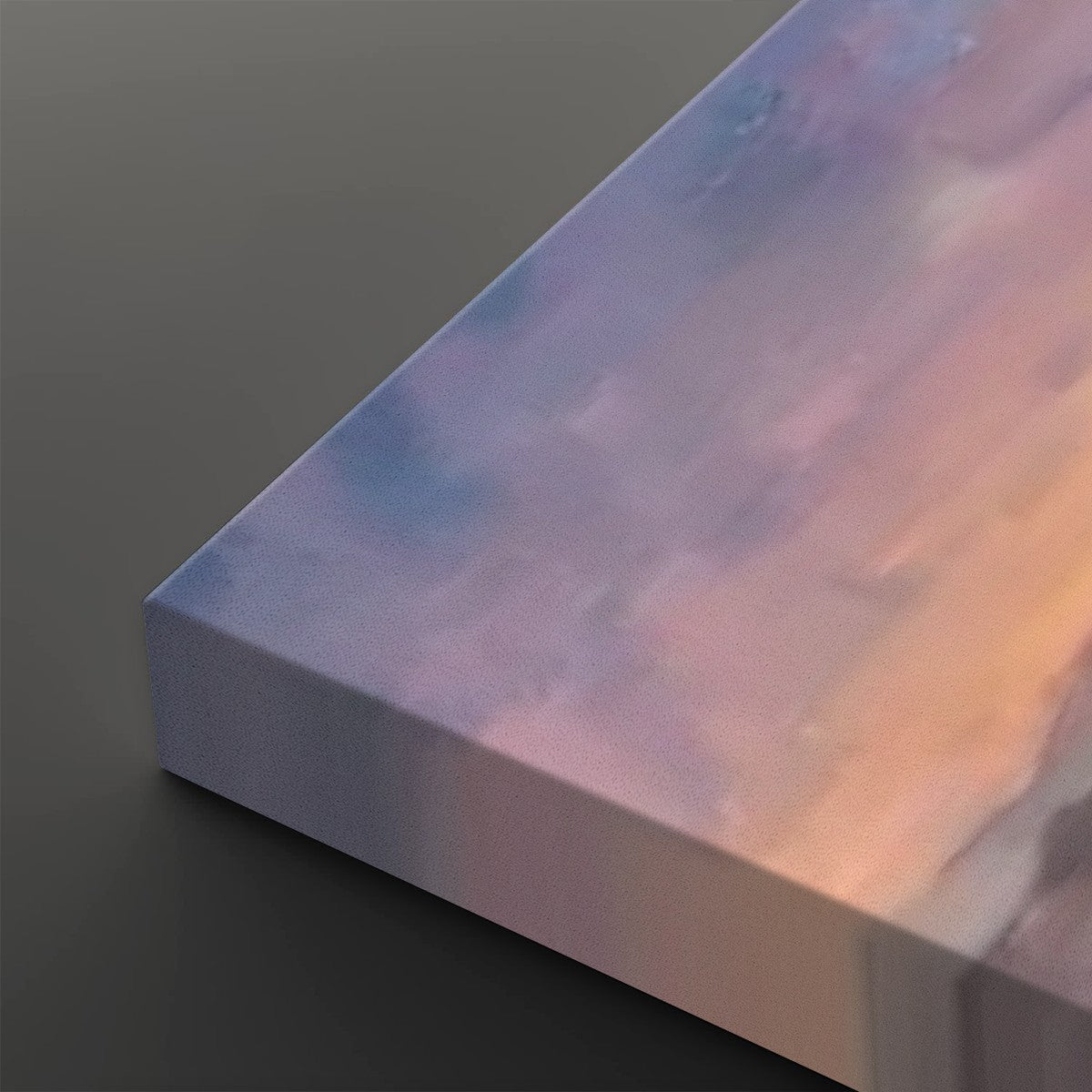 A close-up of a rectangular canvas or block with a soft  pastel lavender, pink, peach, and pale blue, shown on a dark gray background.