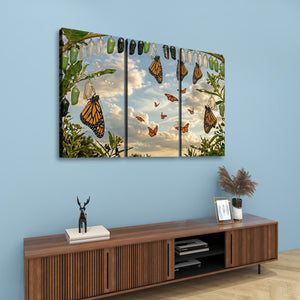 A three-panel canvas wall art set depicting monarch butterflies, shown hanging on a light blue wall above a wooden console table in a styled room setting.