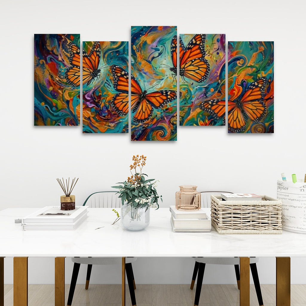 A five-panel canvas wall art set depicting vibrant orange monarch butterflies over colorful swirling abstract backgrounds, displayed on a white wall above a styled dining table with books, a vase, and a basket.