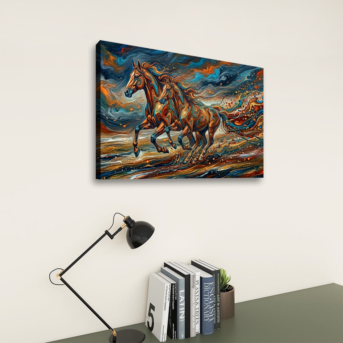 A rectangular canvas wall art print showing two galloping horses in a vivid abstract painting, displayed on a light beige wall above a desk with a black lamp and books.