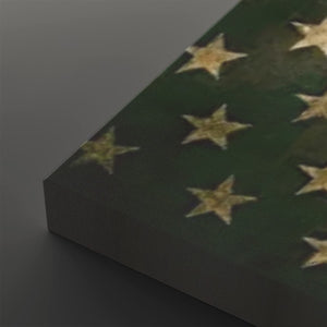 A close-up of a dark green canvas or panel featuring a distressed pattern of gold stars, shown at an angle against a dark gray background.