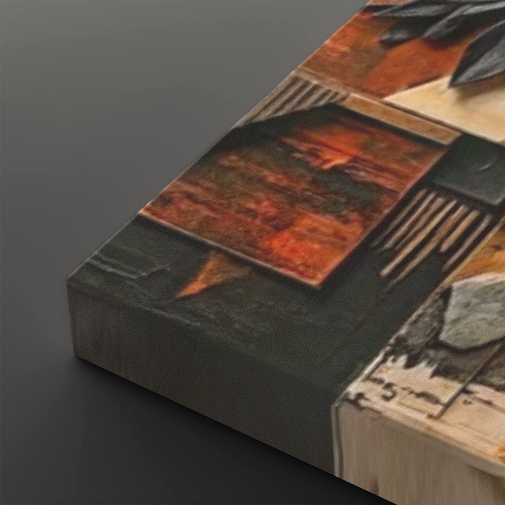 A close-up of a canvas wall art print showing an abstract geometric design with textured panels in rust orange, black, gray, and beige, photographed on a dark gray background.