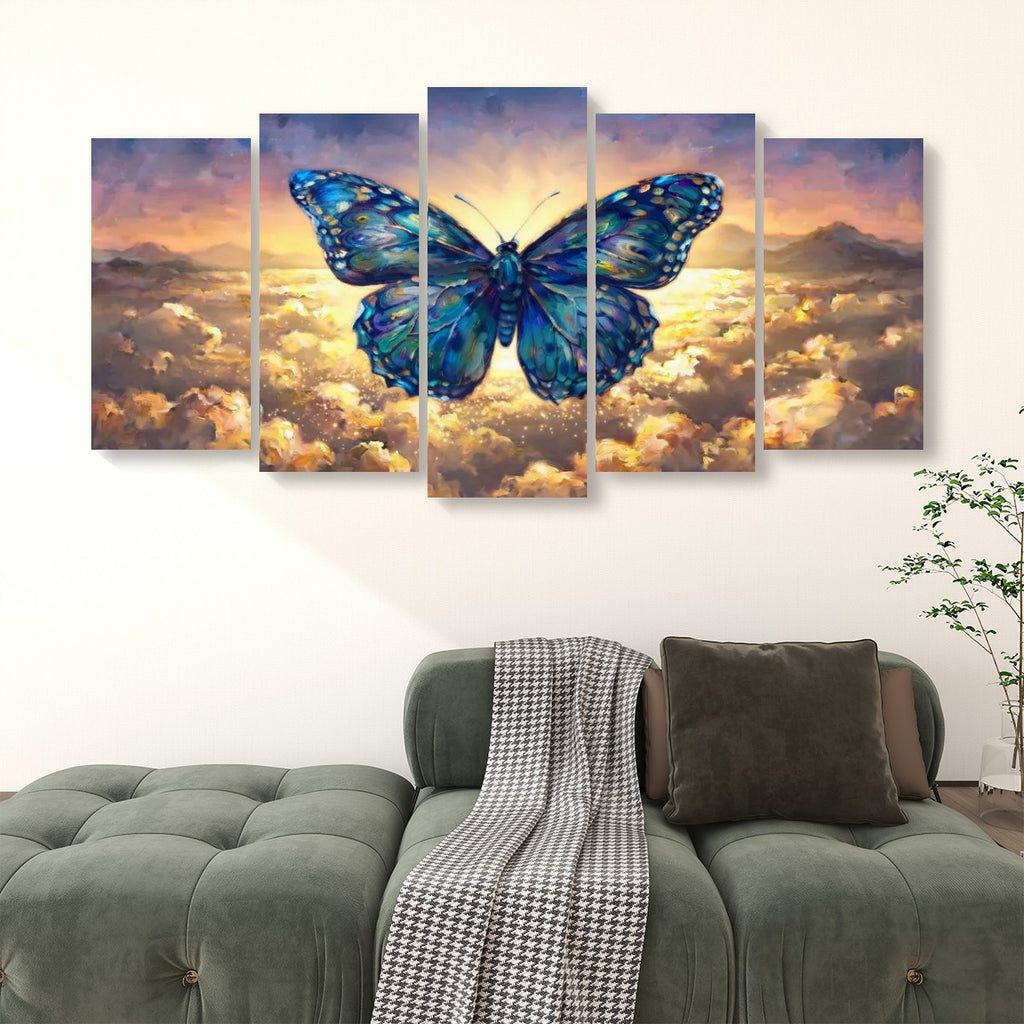 A five-panel canvas wall art set depicting a large blue butterfly over a glowing sky and clouds, displayed above a green sofa in a living room setting.