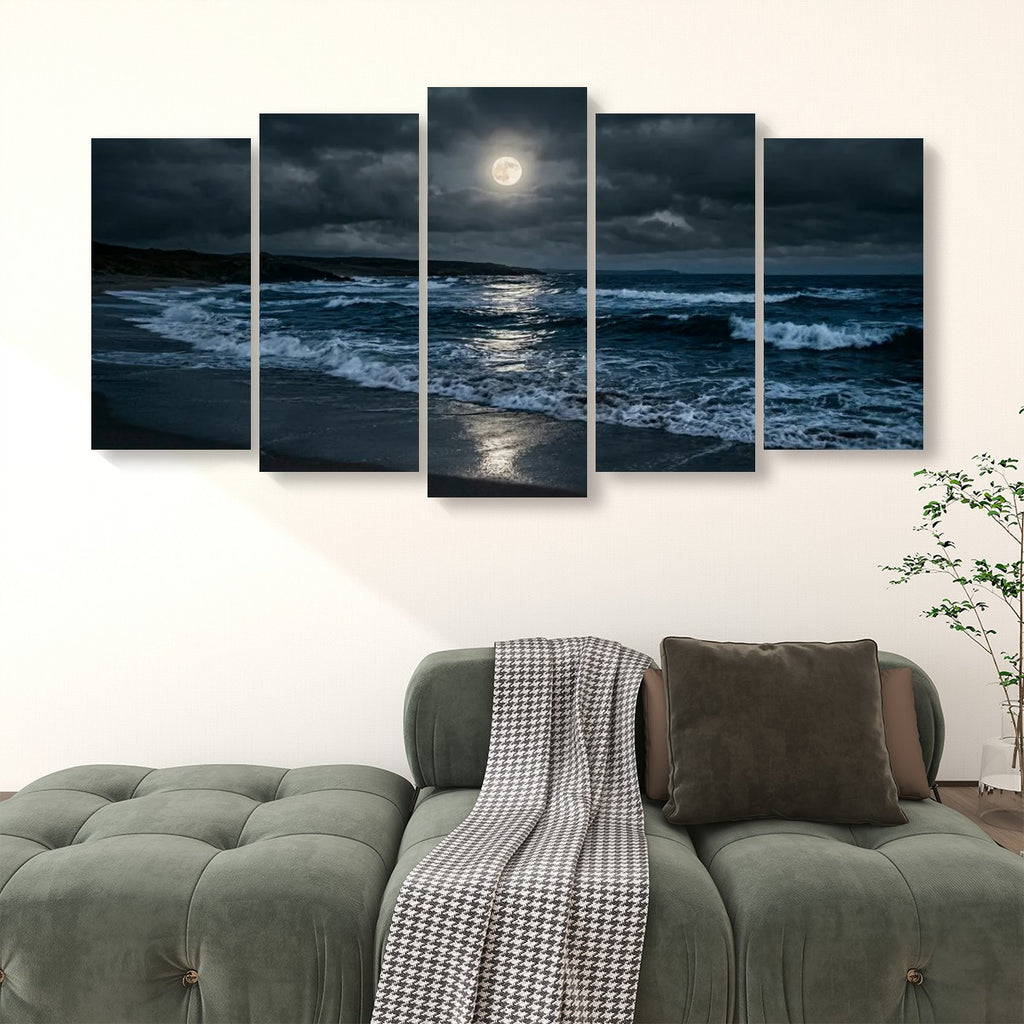 A five-panel canvas wall art set depicting a dramatic moonlit ocean scene with dark clouds, waves, and bright moonlight reflection, displayed above a green sofa in a living room setting.