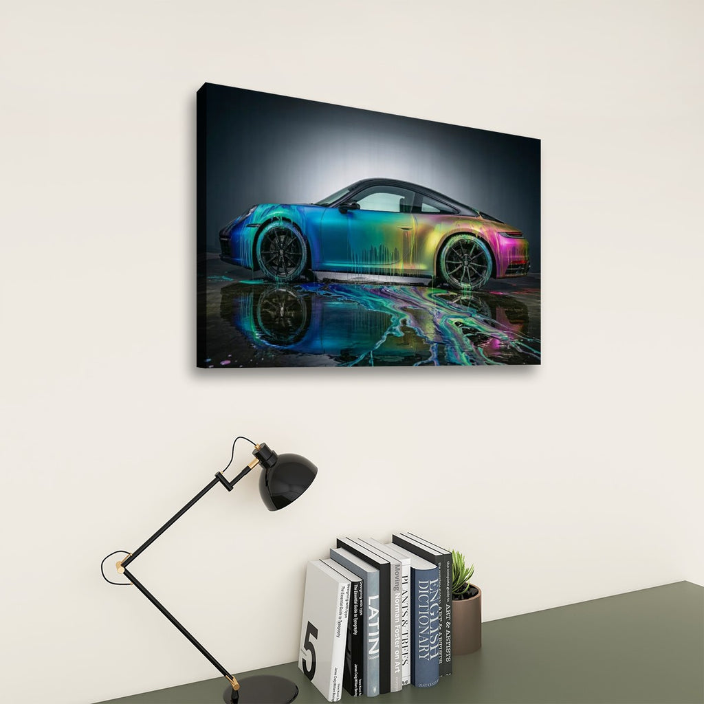 A rectangular wall art print showing a sports car with a vivid rainbow gradient reflection, displayed above a desk with a black lamp and books against a light beige wall.