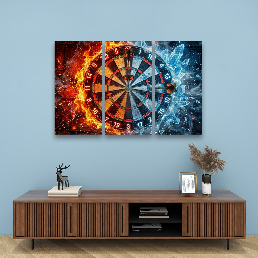 A three-panel canvas wall art set depicting a dartboard split between fiery orange on the left and icy blue on the right, displayed above a wooden console table against a light blue wall.