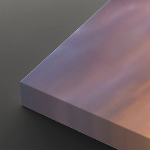 A close-up of a rectangular panel or tile with a smooth, matte finish, showing a color gradient from lavender-purple to soft peach-pink, set against a dark gray background.