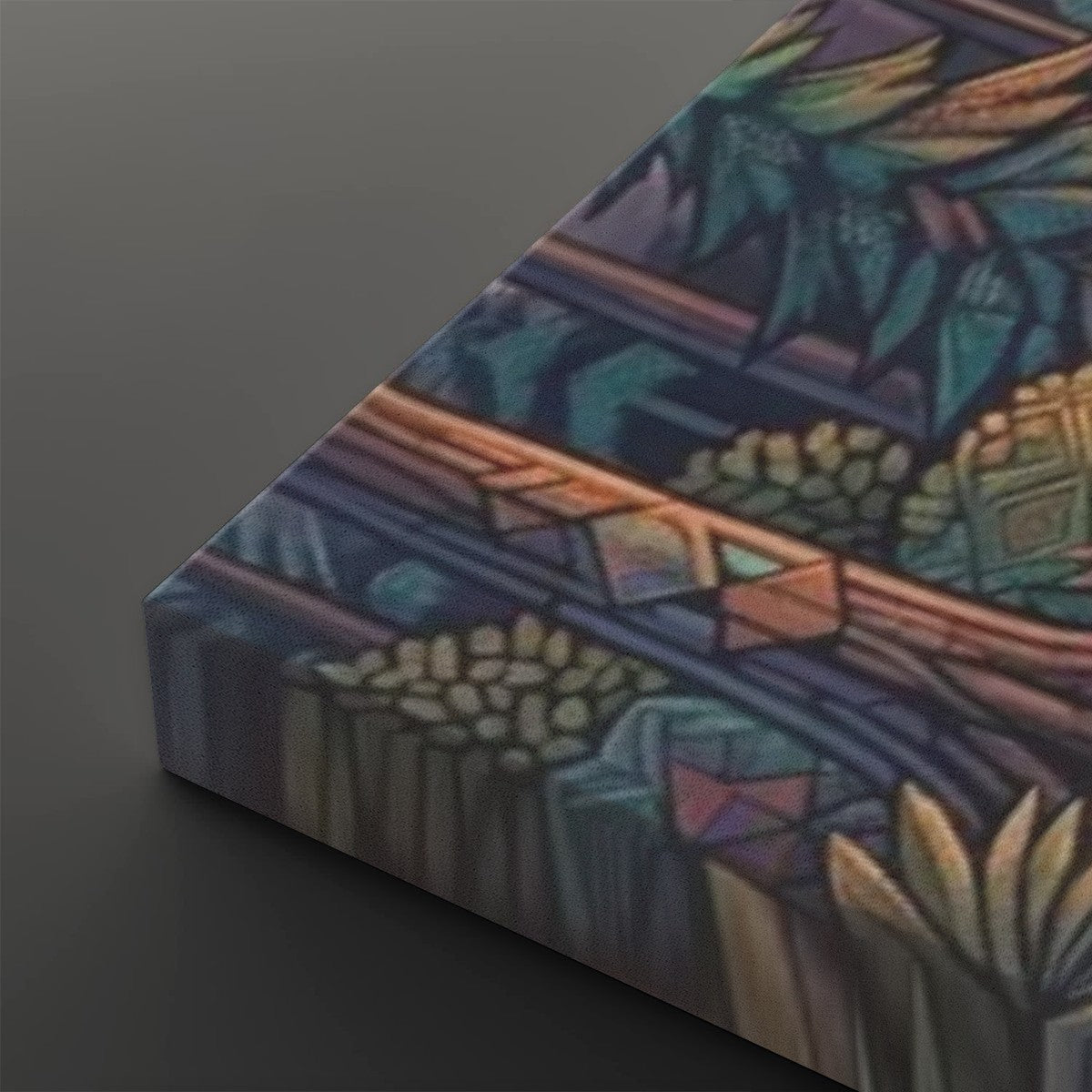 A close-up angled view of a rectangular canvas or print featuring an abstract stained-glass-like design in teal, purple, blue, gold, and brown tones, set against a dark gray background.