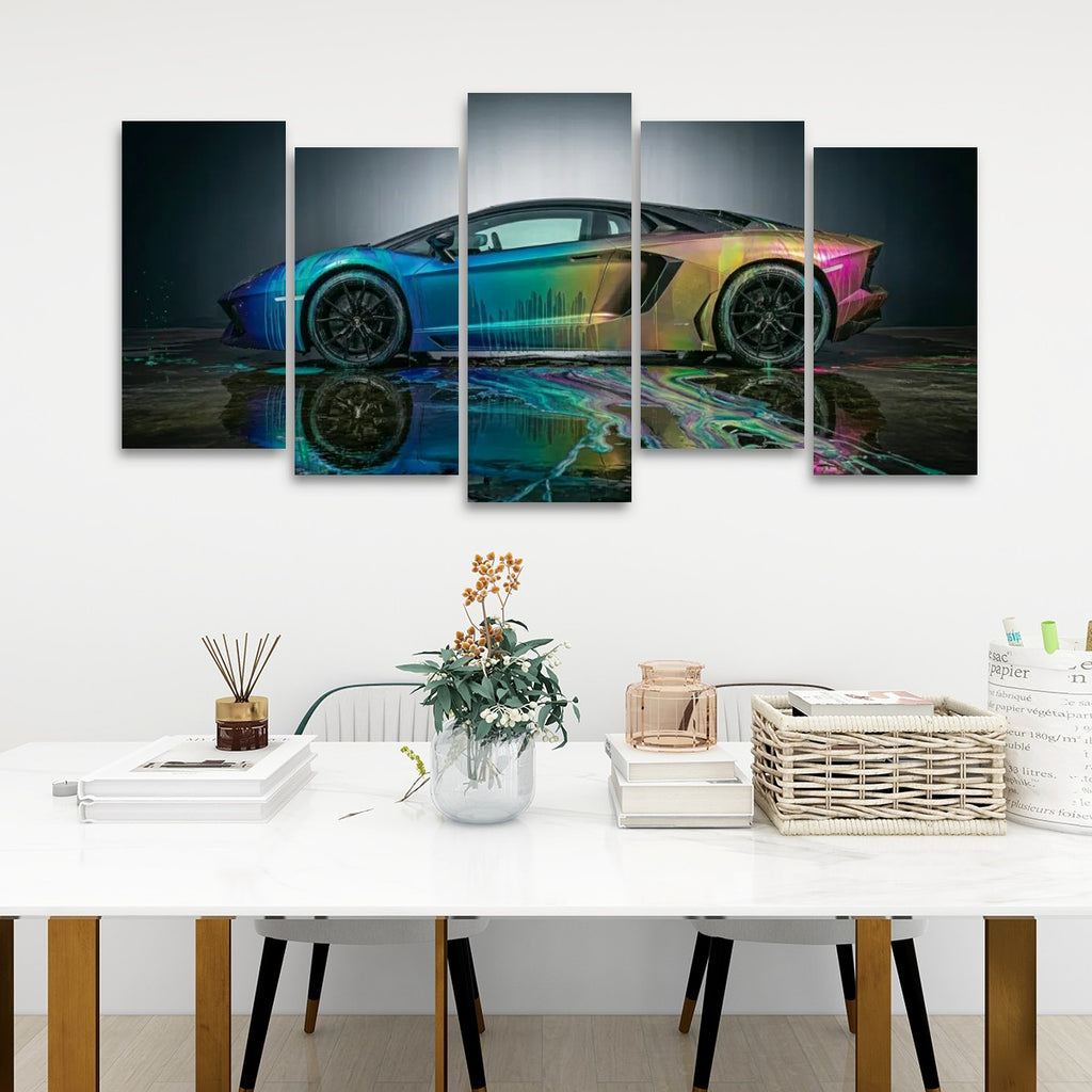 A five-panel canvas wall art set depicting a Lamborghini Aventador sports car with a vibrant rainbow gradient reflection, displayed on a white wall above a styled white table with books, a vase, and a basket.