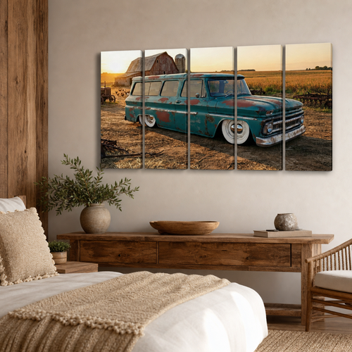 A five-panel canvas wall art print depicting a vintage teal pickup station wagon parked in a rural field at sunset, displayed above a wooden bench in a modern, rustic bedroom setting.