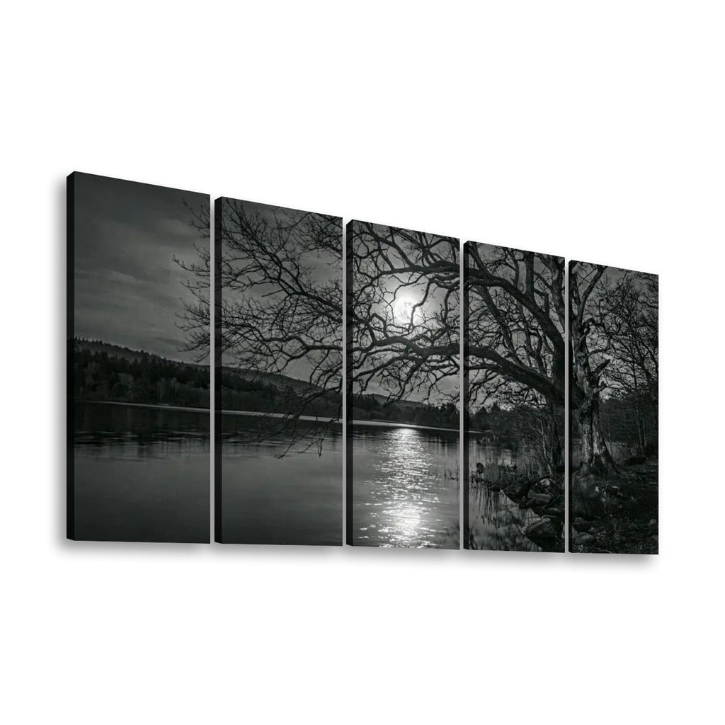 A five-panel black and white canvas wall art set depicting a moody lakeside scene with bare tree branches, dark water, distant hills, and bright moonlight reflection, shown against a plain white background.