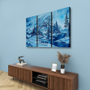 A three-panel canvas wall art set depicting a snowy mountain landscape with a blue river and evergreen trees, displayed on a light blue wall above a wooden console table.