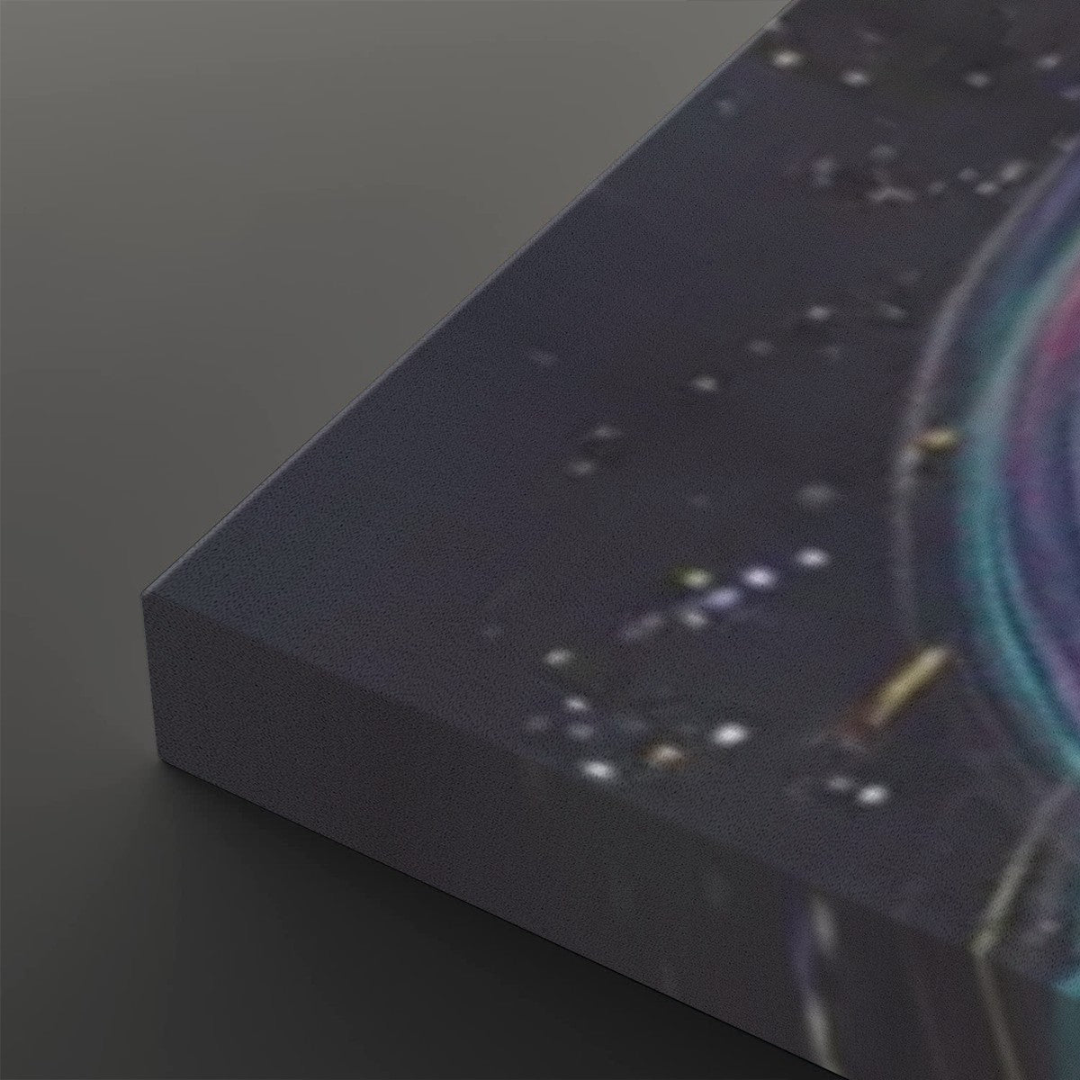 A close-up of a canvas print showing its wrapped edge and a dark cosmic design with stars and a glowing ring in blue, purple, and teal tones.