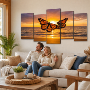 A 5-panel canvas wall art set depicting a monarch butterfly over a golden-orange sunset ocean, displayed on a beige wall above a living room sofa with a couple sitting underneath.