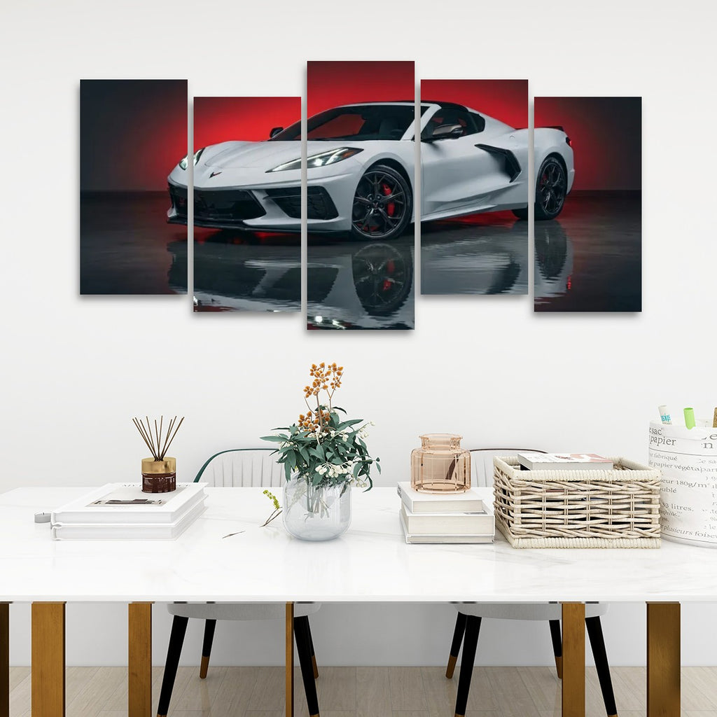 A multi-panel canvas wall art set depicting a white sports car with red accents, displayed above a white dining table in a modern room setting.