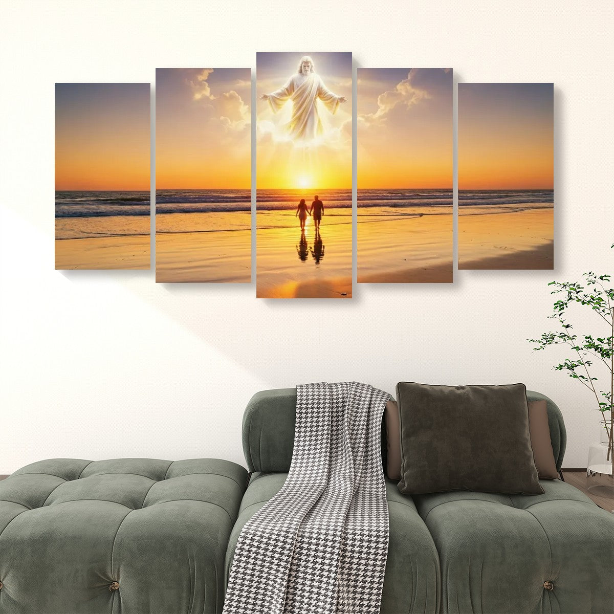 A five-panel canvas wall art set depicting a beach sunset with a glowing figure floating above two small silhouetted figures, displayed above a green sofa in a living room setting.