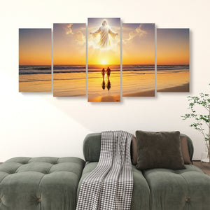 A five-panel canvas wall art set depicting a beach sunset with a glowing figure floating above two small silhouetted figures, displayed above a green sofa in a living room setting.