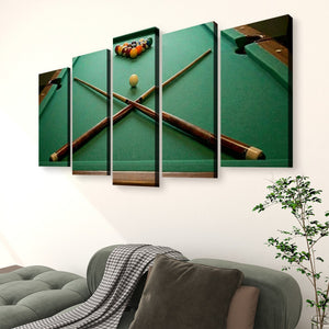 A 5-panel canvas wall art set depicting a green pool table with crossed pool cues and a ball rack, displayed on a white wall above a gray sofa in a living room setting.