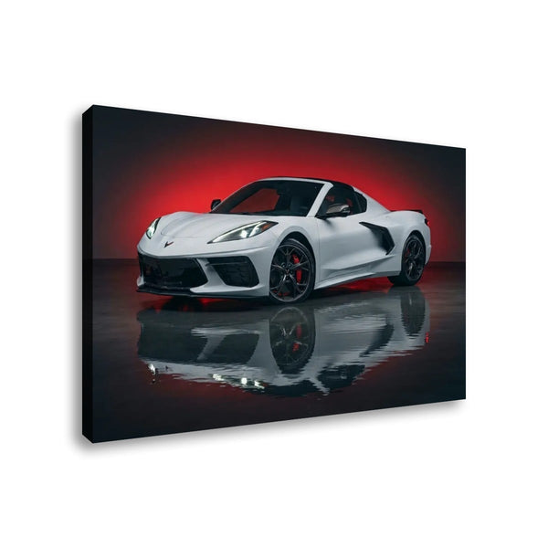A rectangular wall art print or canvas showing a white sports car in a dark studio setting with a red glow behind it and a reflective floor. The print is photographed at an angle against a light gray background.