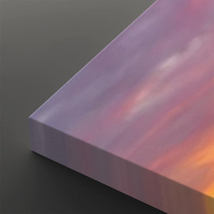 A close-up of a rectangular canvas print showing its wrapped edge, featuring a soft gradient sky design with purple, pink, and orange tones on a dark gray background.