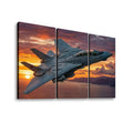 Three-panel canvas wall art showing a gray Grumman F-14 military fighter jet flying over water at sunset, displayed against a plain white background.