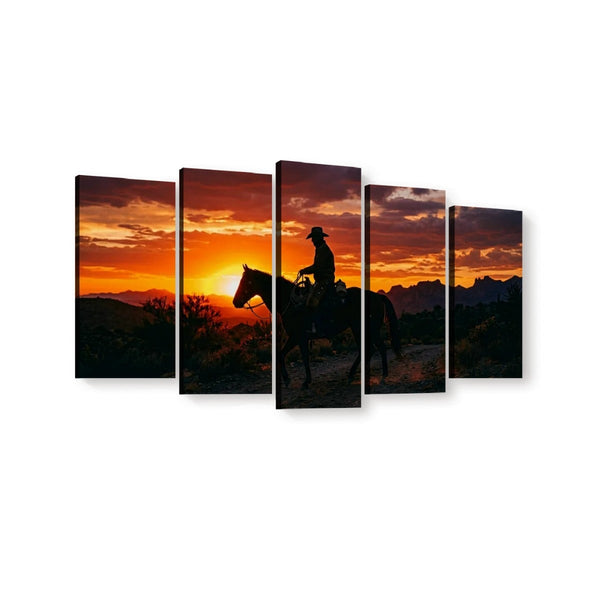 Five-panel canvas wall art showing a cowboy riding a horse across a mountain landscape at sunset, with a dramatic orange and red sky and dark silhouetted foreground.