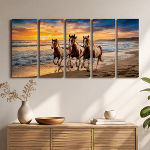 A five-panel canvas wall art set depicting three horses running on a beach at sunset, displayed on a wall above a wooden console table with decorative vases and books.