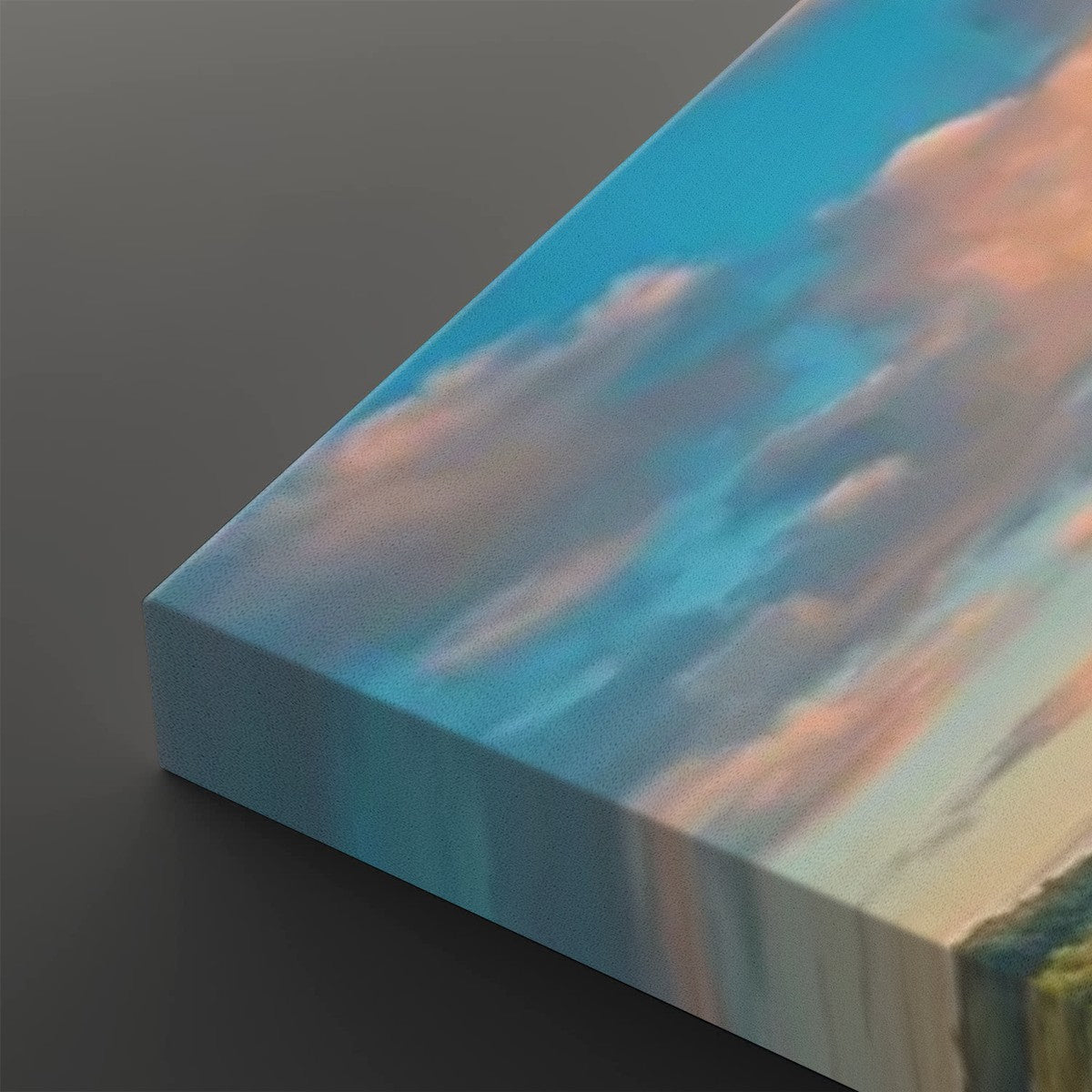 A close-up of a rectangular canvas or panel showing a painted sky scene with blue sky, soft pink clouds, and a strip of green landscape at the bottom, photographed on a dark gray background.
