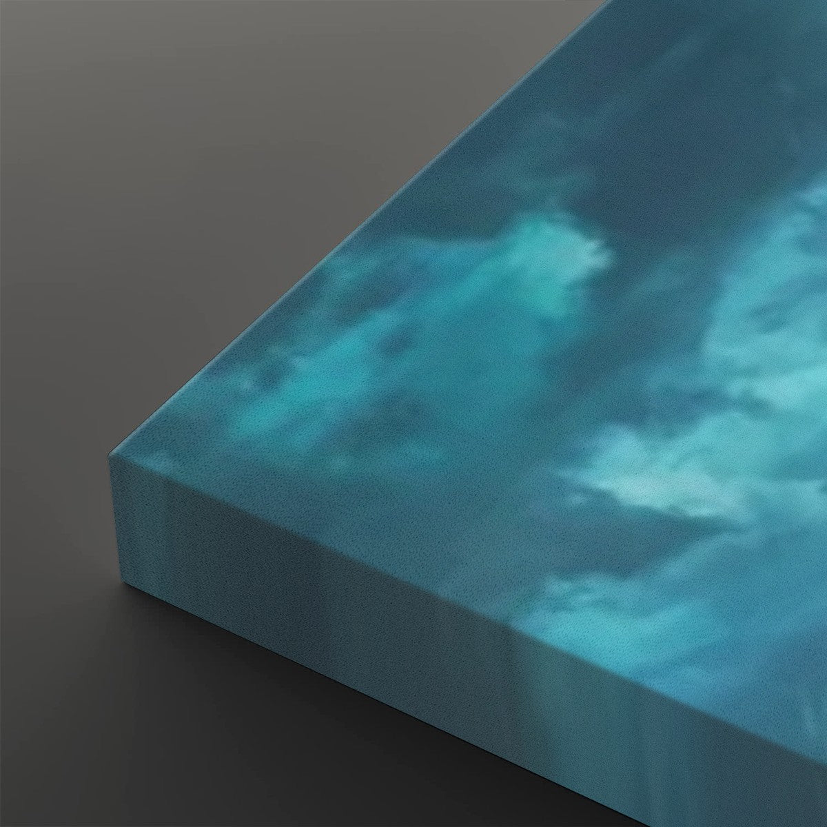 A close-up of a square canvas print showing its wrapped edge, featuring a textured blue and teal cloudy sky design on a dark gray background.