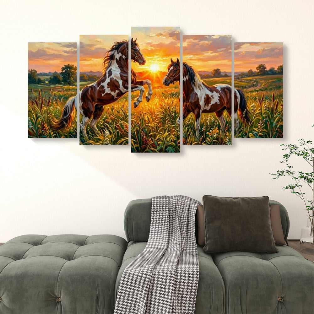 A five-panel canvas wall art set depicting two brown and white pinto horses in a golden field at sunset, displayed above a green tufted sofa in a living room setting.