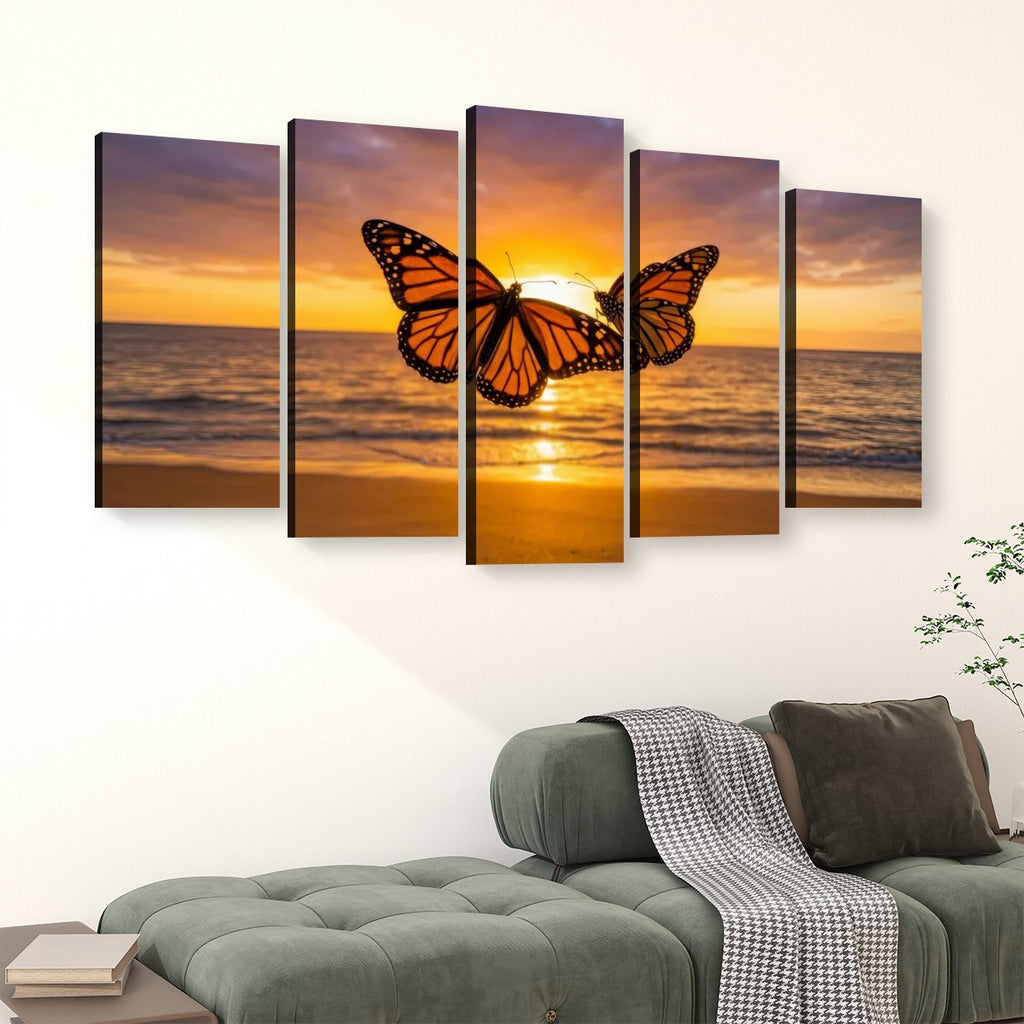 A five-panel canvas wall art set depicting a monarch butterfly flying over an ocean sunset, displayed on a white wall above a green sofa in a living room setting.