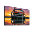 Three-panel canvas wall art showing a red Chevrolet truck at sunset with its reflection on the water, displayed against a white background.