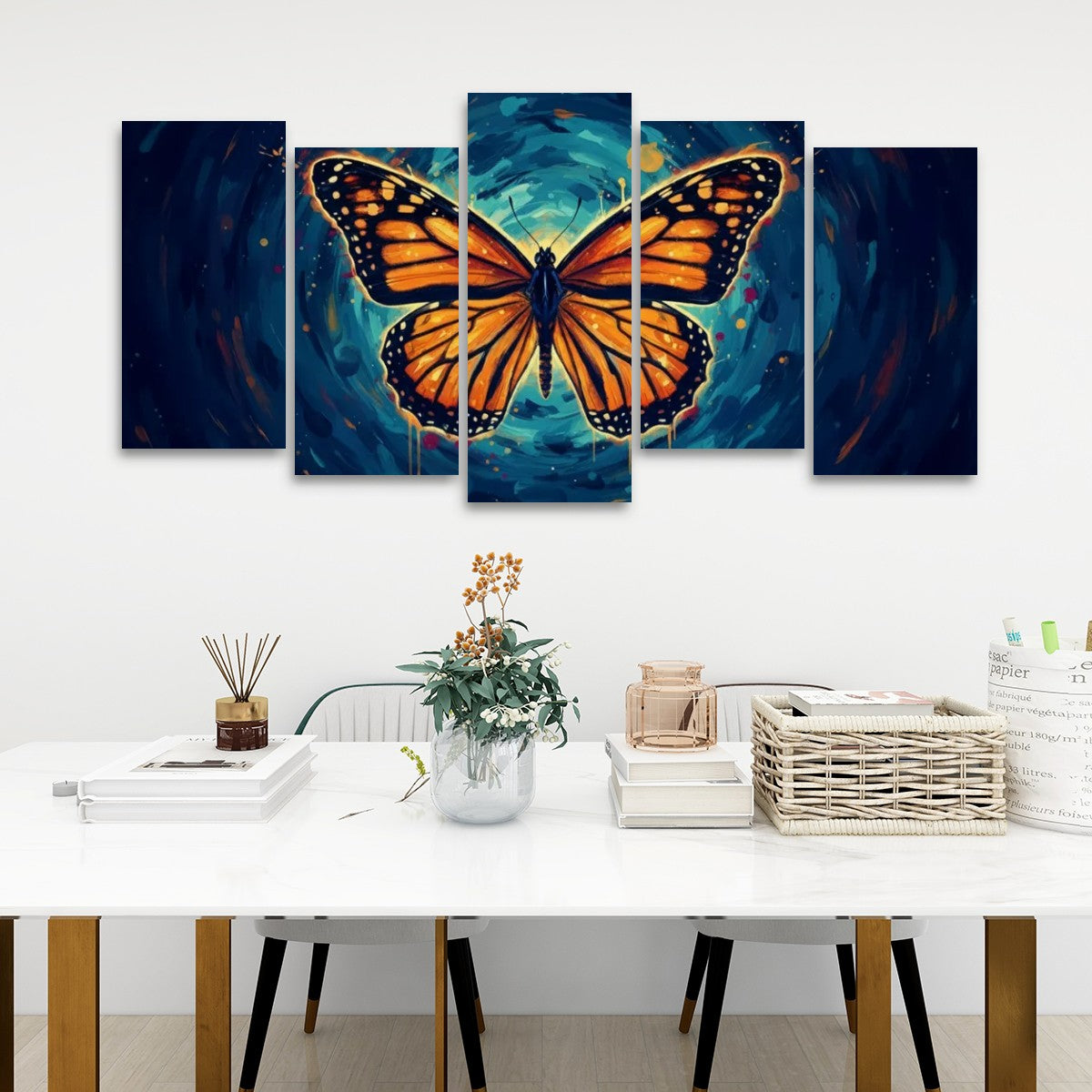 A five-panel canvas wall art set depicting a large orange monarch butterfly over a swirling blue and teal background, displayed above a white table in a modern room setting.