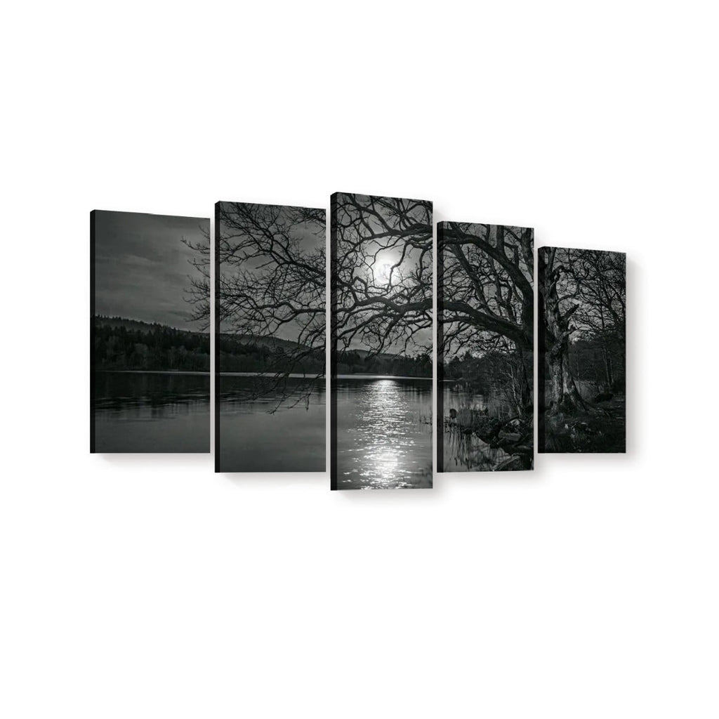 A five-panel canvas wall art set depicting a black and white landscape scene with bare tree branches over a reflective lake at night under a bright moon.