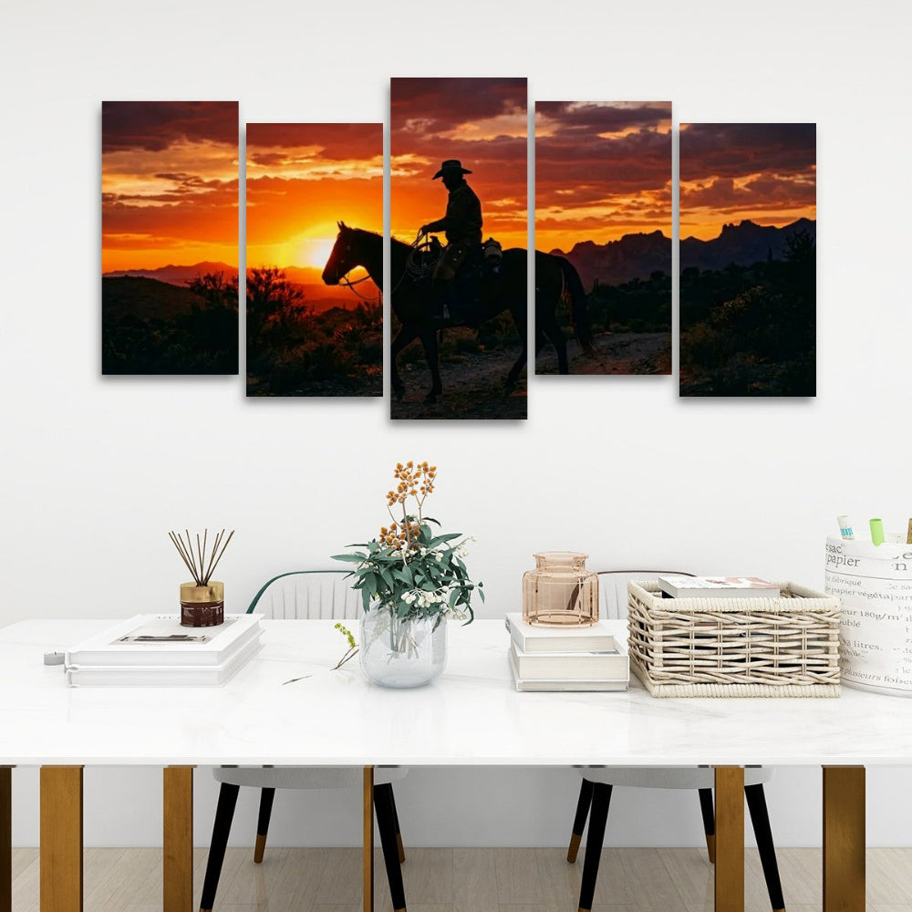 A five-panel canvas wall art set depicting a cowboy riding a horse at sunset, displayed on a white wall above a styled dining table with books, a vase, and baskets.