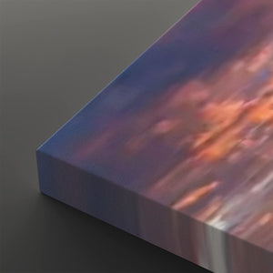 A close-up of a rectangular canvas or print showing an abstract painted scene with blue, purple, pink, and orange tones, photographed on a dark gray background.