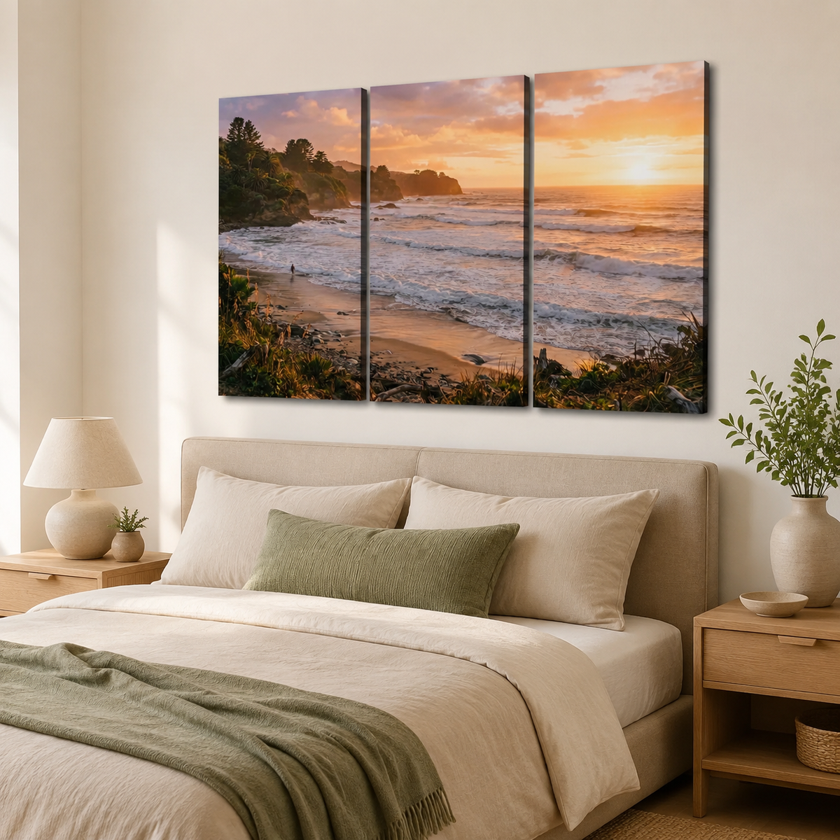 A three-panel canvas wall art print depicting a beach sunset scene, displayed above a neatly made bed in a modern, warm-toned bedroom.