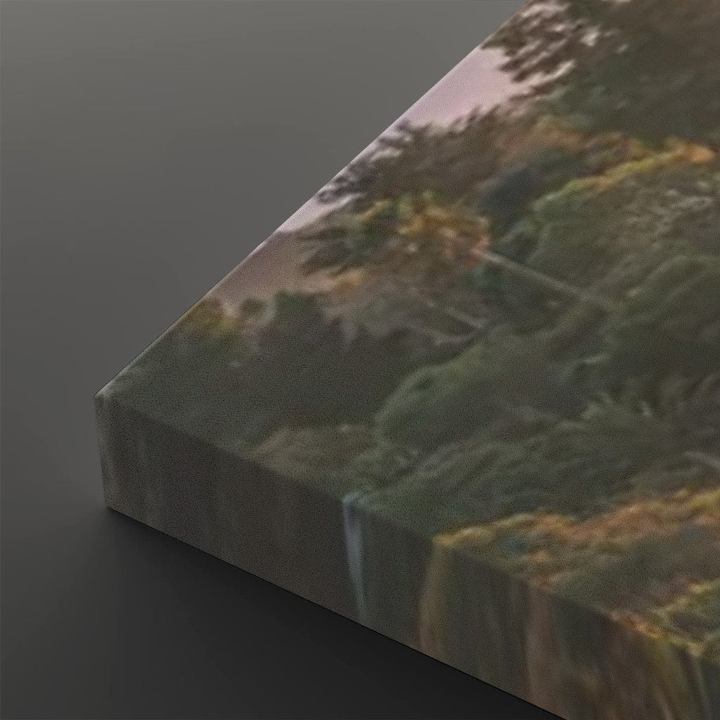 A rectangular canvas print showing a forest landscape with trees and foliage, photographed at an angle on a dark gray background.