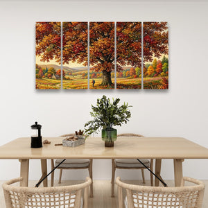 A five-panel canvas wall art set depicting a large autumn tree with orange and red foliage over a golden field, displayed above a light wood dining table in a modern room setting.