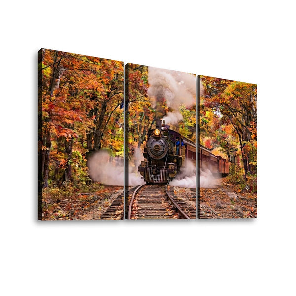 A three-panel canvas wall art print depicting a black steam locomotive traveling on tracks through a forest with vibrant orange and yellow autumn foliage, shown against a plain white background.