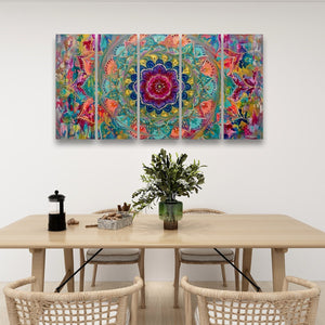 A colorful abstract floral mandala wall art set displayed in a modern dining room setting above a light wood table with woven chairs.