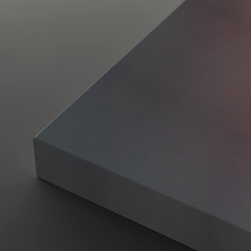 A close-up studio shot of a matte gray rectangular block or panel corner, shown against a matching dark gray background with soft warm light on the top surface.