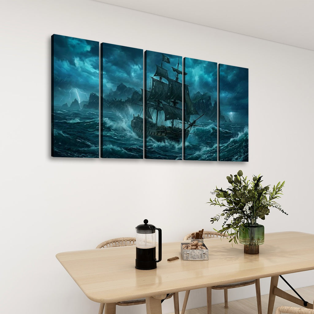 A 5-panel canvas wall art set depicting a dramatic pirate ship sailing through dark, stormy blue-green seas, displayed on a white wall above a light wood dining table with a vase of greenery and a French press.